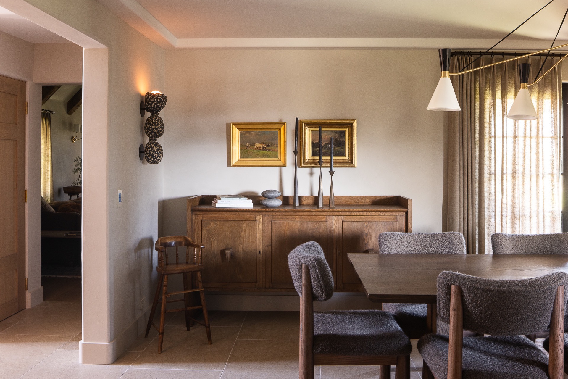 Adobe Canyon dining room with upholstered chairs, a wood sideboard and framed paintings